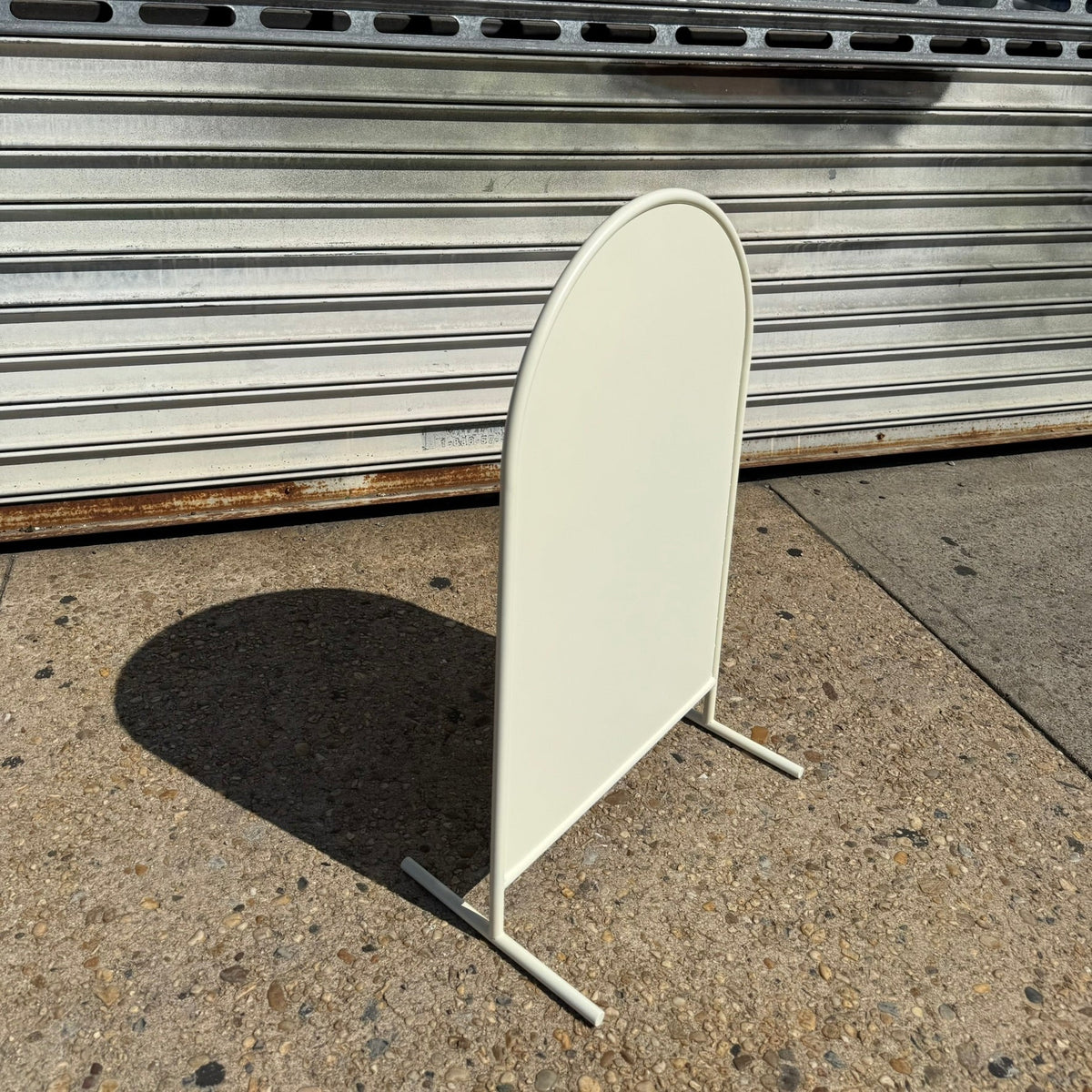 Left angled view of a blank cream arched standing sign.