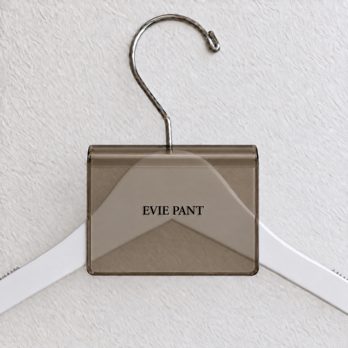 Bronze Smoke transparent acrylic hanger sign clip with soft edge reflections, resting on a white wooden hanger, with example EVIE PANT print