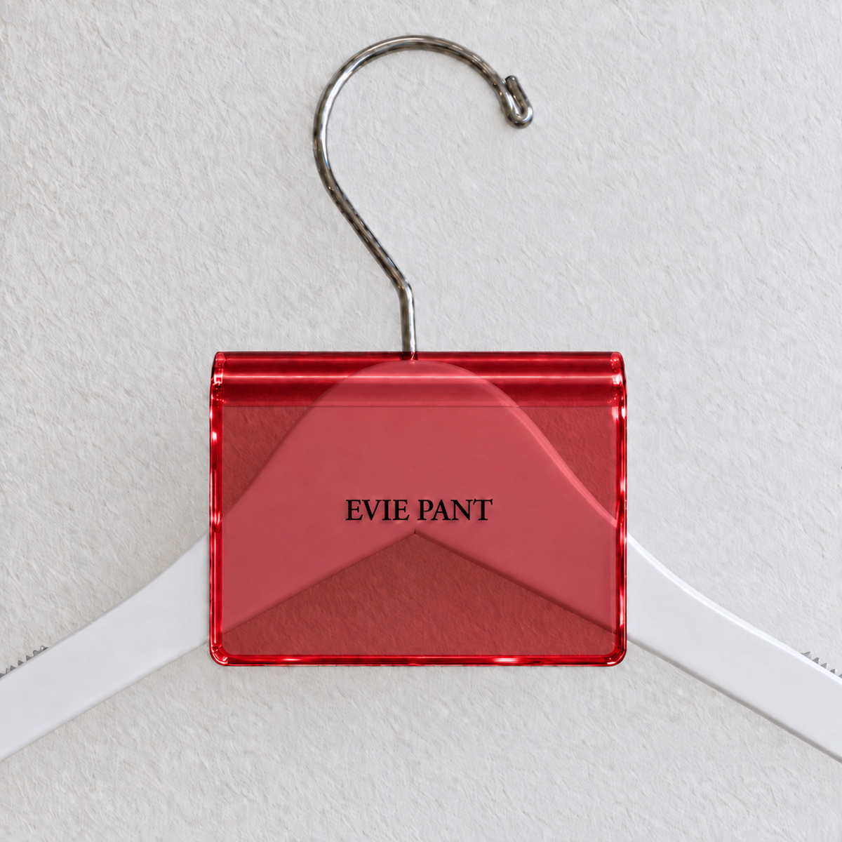 Red acrylic hanger sign clip resting on the rounded crown of a white wooden hanger, with example EVIE PANT print