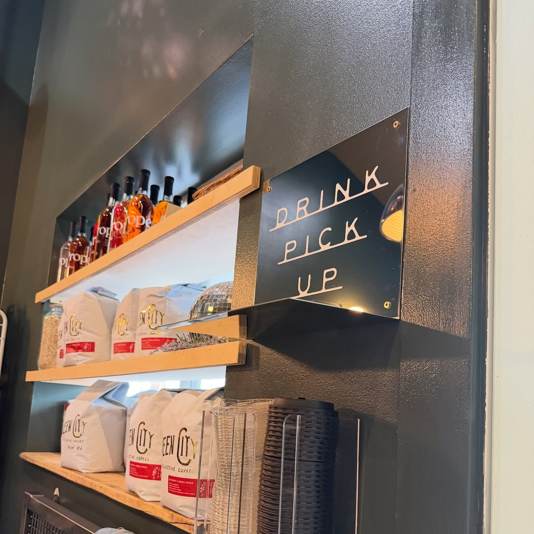 Mirror Shelf with drinks and snacks above a drink pick-up area in a store.