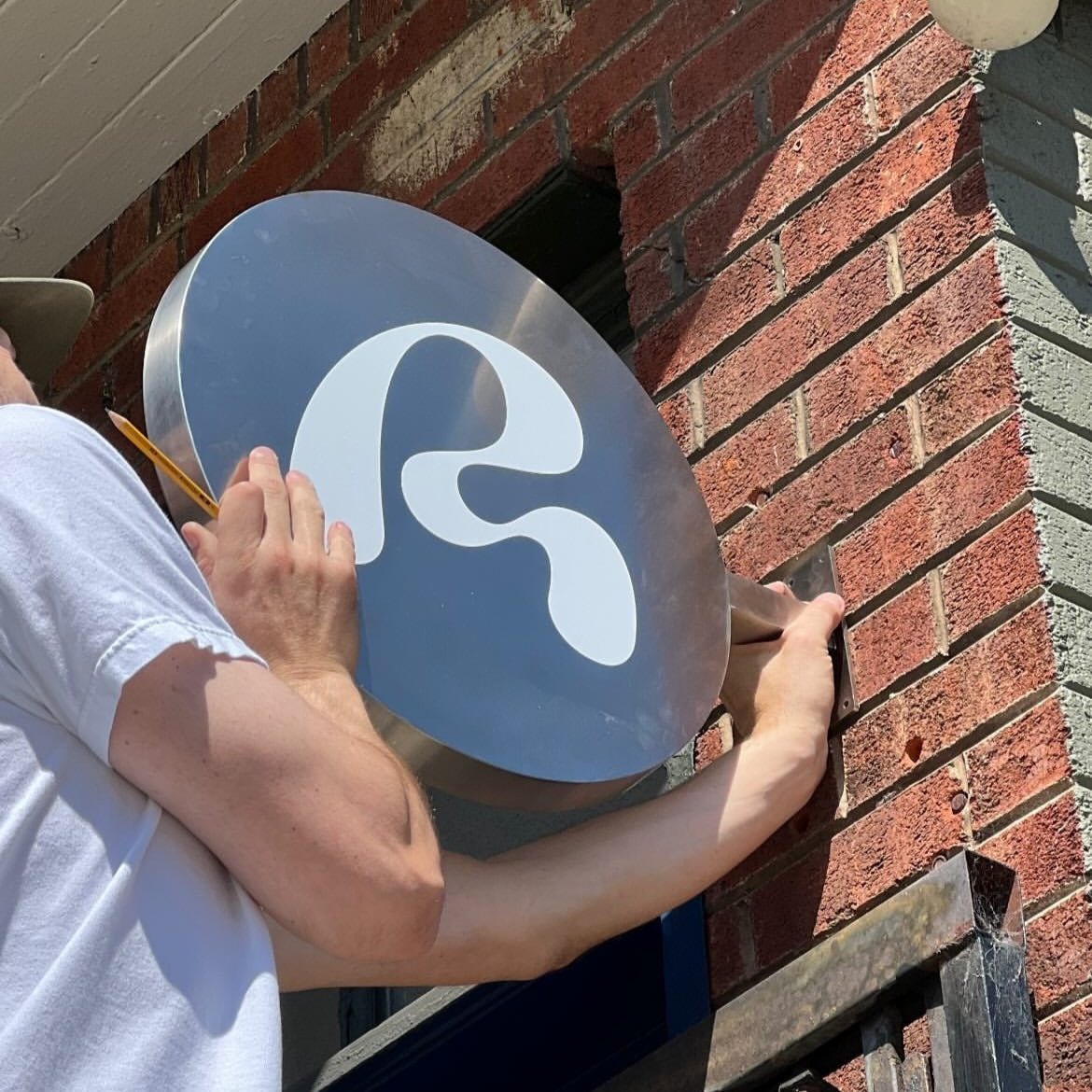 Round dimensional stainless steel wall sign with 3D effect