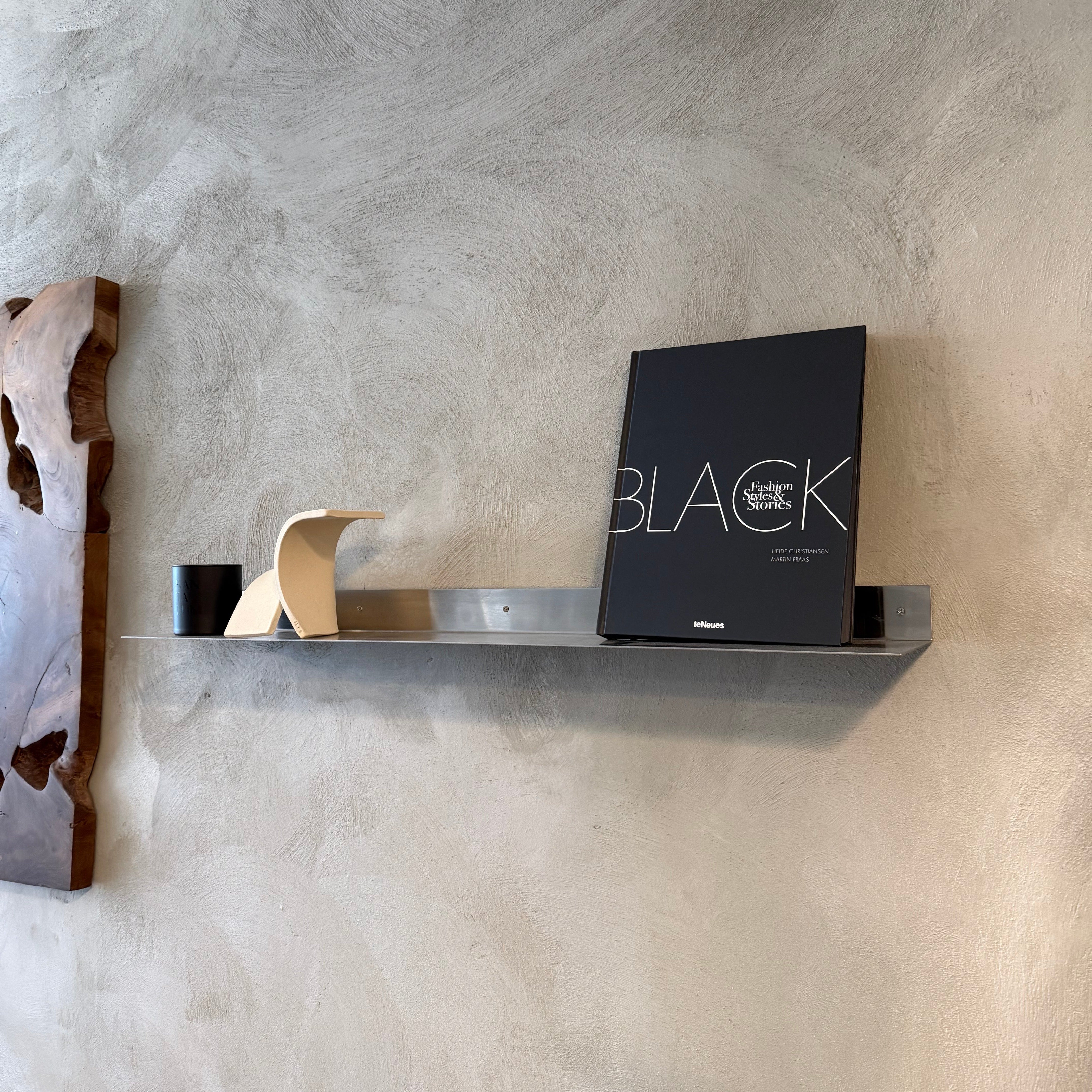 Shelf with decorative items against a textured wall