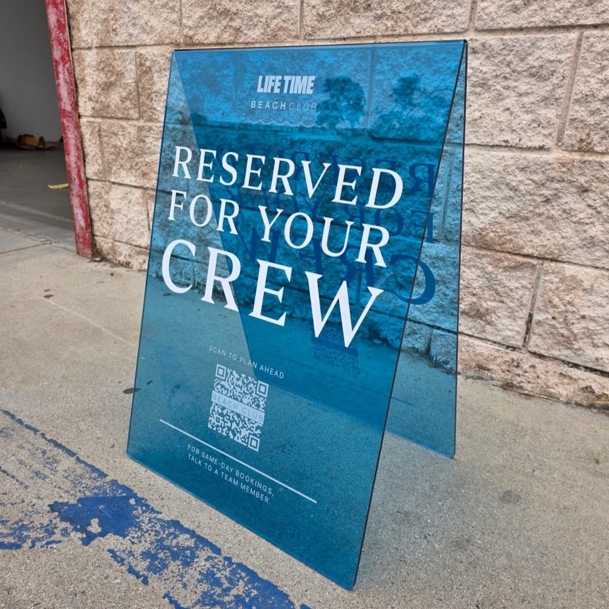 Angled view of a blue acrylic Life Time sign with Reserved for Your Crew lettering.