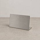 Landscape brushed stainless steel tabletop stand with a bent base.