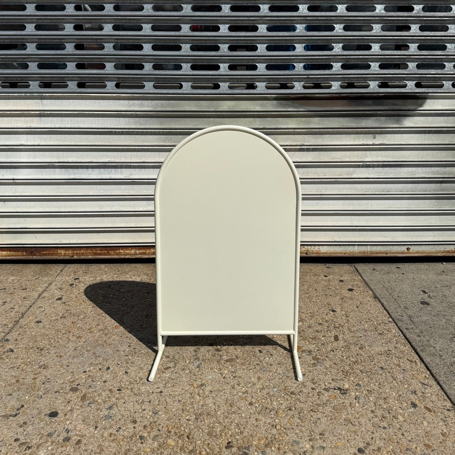 Front view of a blank cream arched standing sign.
