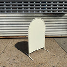 Right angled view of a blank cream arched standing sign.