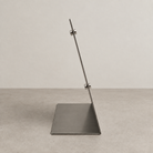 Side profile of a stainless steel tabletop stand showing its base and small attached magnets.